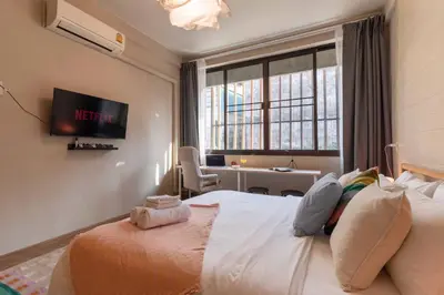 a bedroom with a bed and a desk and a window at Walk2BTS, KingBed, FastWiFi, FreeLaundry, Netflix in Khlong Toei