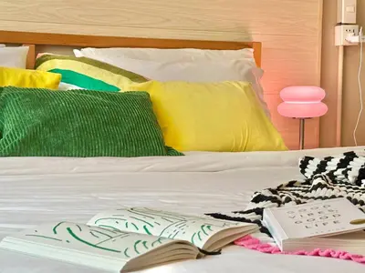 a bed with an open book on it with a book at Walk2BTS, KingBed, FastWiFi, FreeLaundry, Netflix in Khlong Toei