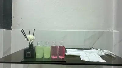 a glass shelf with several different colored bottles on it at Villa Moon Terrace in Bang Khen