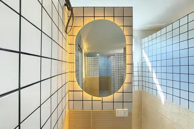 a mirror on the wall of a bathroom at Nana Best Hostel in Makkasan