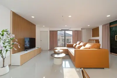 a living room with a couch and a tv at Capitel Sathorn in Yan Nawa