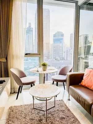 a living room with a couch and a table at Stylish Luxury 1 Bedroom, Hyde Sukhumvit 11, Near BTS Nana & Asok in Bangkok