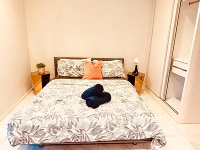 a bedroom with a large bed with orange pillows at Stylish Luxury 1 Bedroom, Hyde Sukhumvit 11, Near BTS Nana & Asok in Bangkok