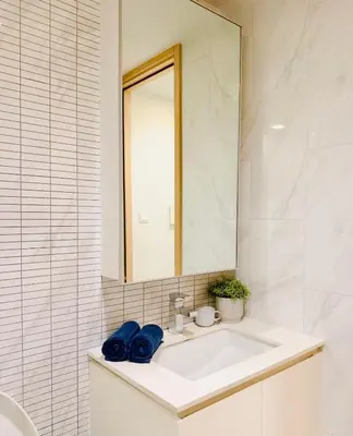 a white bathroom with a sink and a mirror at Stylish Luxury 1 Bedroom, Hyde Sukhumvit 11, Near BTS Nana & Asok in Bangkok