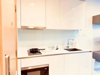 a white kitchen with white cabinets and a sink at Stylish Luxury 1 Bedroom, Hyde Sukhumvit 11, Near BTS Nana & Asok in Bangkok