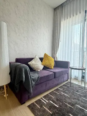 a purple couch in a living room with a window at 072-Cap-A-R266-F24 in Ban Na Song