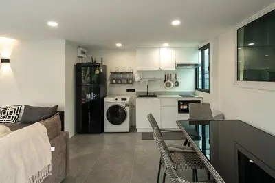 a kitchen and living room with a couch and a table at The Lodge Bangkok Poolvilla 2 in Sathani Khlong Tan