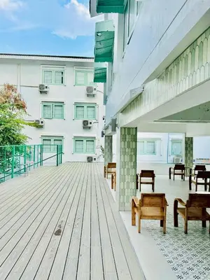 a wooden deck with benches and a building at Easy Monday Pool Capsule Hotel - Old Town Bangkok in Bangkok