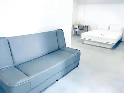 a blue couch and a bed in a room at XX Mitr INN Sukhumvit Soi 2 in Bang Kapi
