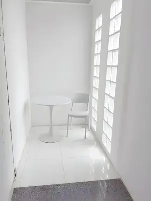 a white room with a table and a chair at XX Mitr INN Sukhumvit Soi 2 in Bang Kapi