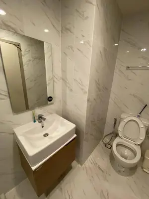 a white bathroom with a sink and a toilet at Bangna Apartment Ideo in Ban Khlong Samrong