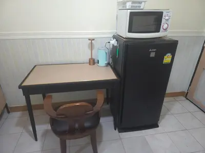 a microwave sitting on top of a small refrigerator at 114 Boutique style apartment with Air Con and free Wi-fi in Bangkok
