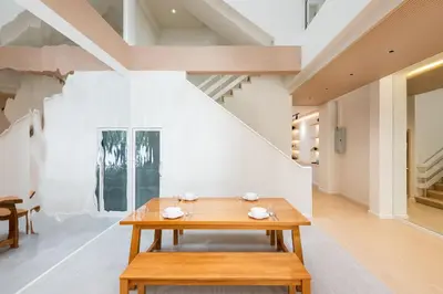 a dining room with a wooden table and chairs at Spacious 4BR Muji Home with Loft Pool in Ekkamai in Bangkok