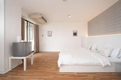 a white bedroom with a bed and a tv at Stylish Twin BR w Ensuite Bath & Relaxing Tub BTB7 in Bangkok