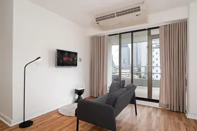 a living room with a couch and a large window at Stylish Twin BR w Ensuite Bath & Relaxing Tub BTB7 in Bangkok