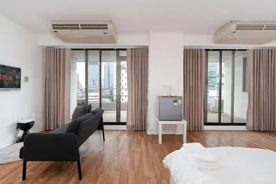 a white room with two beds and a television at Stylish Twin BR w Ensuite Bath & Relaxing Tub BTB7 in Bangkok