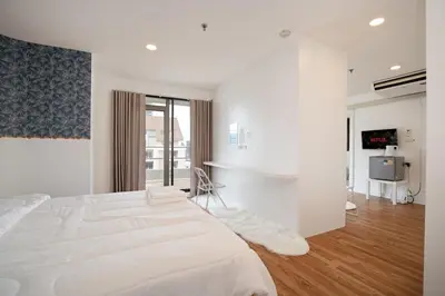 a white bedroom with a large bed and a television at Elegant King BR Apt Bathtub, BTS Central BKK BTB8 in Bangkok