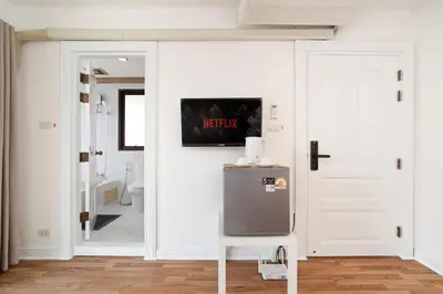 a bathroom with a refrigerator and a white door at Elegant King BR Apt Bathtub, BTS Central BKK BTB8 in Bangkok