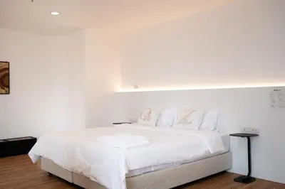 a white bedroom with a large bed with white sheets at Chic King Bed Apt w Bathtub, BTS Central BKK BTB9 in Bangkok