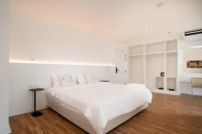 a white bedroom with a large white bed with pink pillows at Chic King Bed Apt w Bathtub, BTS Central BKK BTB9 in Bangkok