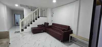 a living room with a couch and a staircase at Kea House 1- 4BR Vacation house near Airport, Family friendly in Bang Khen