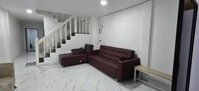 a living room with a couch and a staircase at Kea House 1- 4BR Vacation house near Airport, Family friendly in Bang Khen