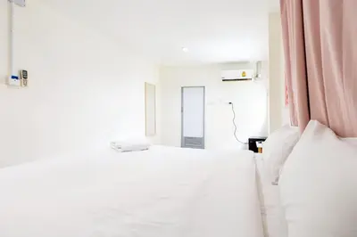 a bedroom with two white beds and a pink curtain at xx Oh My Napz Sukhumvit 3 - สุขุมวิท ซอย 3 in Makkasan
