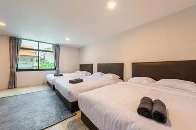 a hotel room with two beds with slippers on them at SavasdeeVilla Midtown bangkok in Makkasan