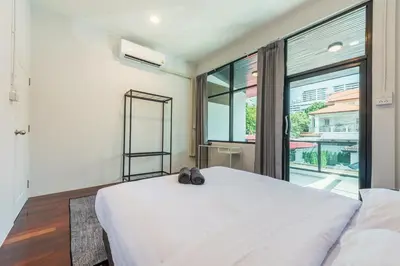 a bedroom with a white bed and a large window at SavasdeeVilla Midtown bangkok in Makkasan