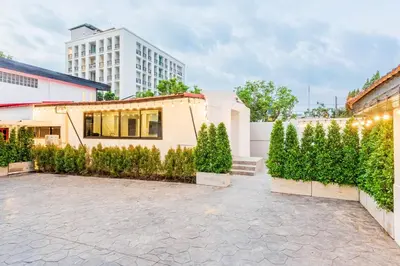 a house with a hedge in front of a building at SwasddeeHouse midtown bangkok in Makkasan