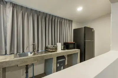 a kitchen with a sink and a refrigerator at SwasddeeHouse midtown bangkok in Makkasan