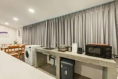 a room with a counter with a microwave and a table at SwasddeeHouse midtown bangkok in Makkasan