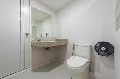 a white bathroom with a toilet and a sink at SwasddeeHouse midtown bangkok in Makkasan