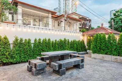 a picnic table and benches in a courtyard at SwasddeeHouse midtown bangkok in Makkasan