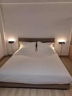 a large bed with white sheets and pillows at Brown H in Pom Prap