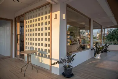 a building with windows and a stool in a room at Morning Place in Ban Krathum Lom