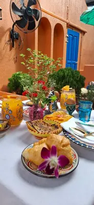 a table with plates of food and flowers on it at Dar Wafa Riad, Restaurant and Hamam in Bangkok