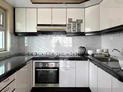 a kitchen with white cabinets and a stove top oven at Bann-Kun Impact Muang Thong 2BR Condo Wi-Fi MRT Pink Near Airport DM