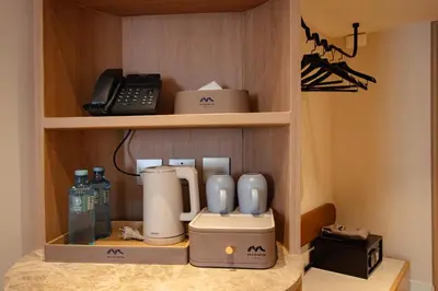 a coffee maker and a phone on a shelf at Marwin Terra Hotel in Bangkok