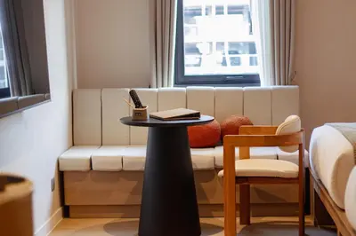 a room with a bed and a table and a couch at Marwin Terra Hotel in Bangkok