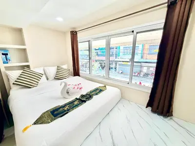 a bedroom with a white bed with a window at PSA Palace Khaosan in Bangkok