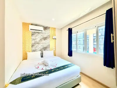 a bedroom with a bed and a window at PSA Palace Khaosan in Bangkok