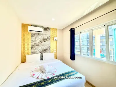 a bedroom with a bed and a window at PSA Palace Khaosan in Bangkok