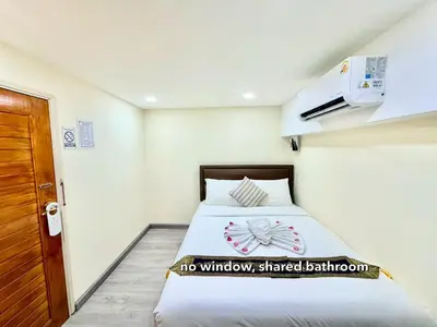 a small bedroom with a bed and a door at PSA Palace Khaosan in Bangkok