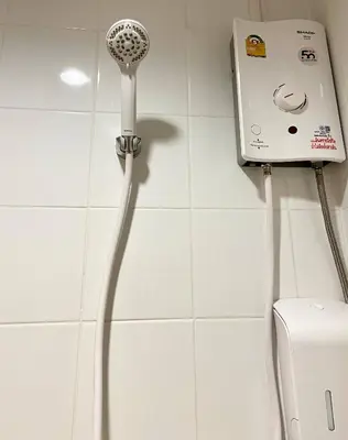 a blow dryer in a bathroom next to a toilet at 1-Min Walk to BTS Thonglor Simple Spotless Great Value Stay in Khlong Toei