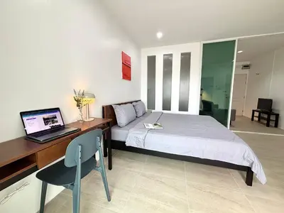a bedroom with a bed and a desk with a laptop at 1minBTS-Wifi500Mbs-Workplace>NETFLIX/Central in Khlong Toei