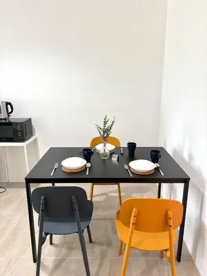 a dining room table with two chairs and a black table with plates at 1minBTS-Wifi500Mbs-Workplace>NETFLIX/Central in Khlong Toei
