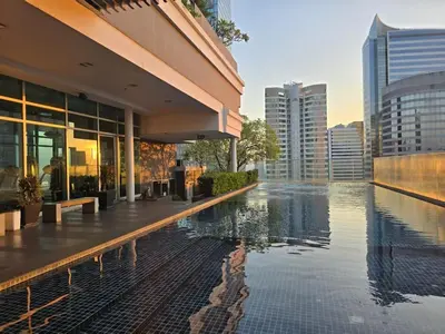 a building with a swimming pool in front of a city at MahaNakhon Silom Sathon in the heart of Bangkok in Bangkok