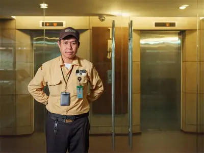 a man is standing in front of a elevator at Silom Lofts in Bangkok