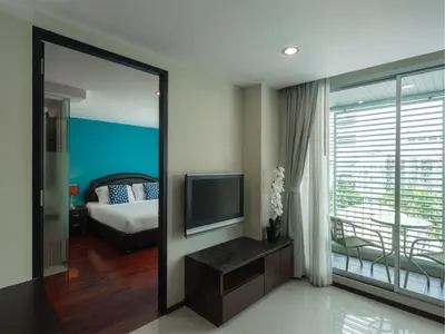a bedroom with a bed and a television in a room at Silom Lofts in Bangkok